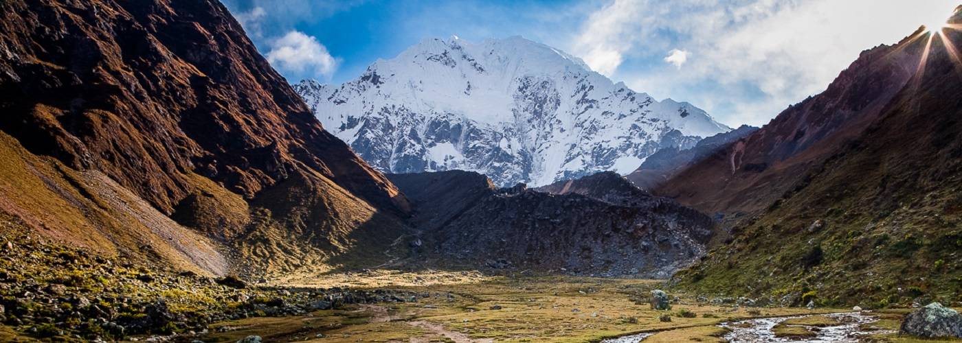 The sun flares over a ridge while we stop to take in the beautiful alpine creek on our way to Salkantay Pass (15,000 ft) en route to Machu Picchu, Peru.